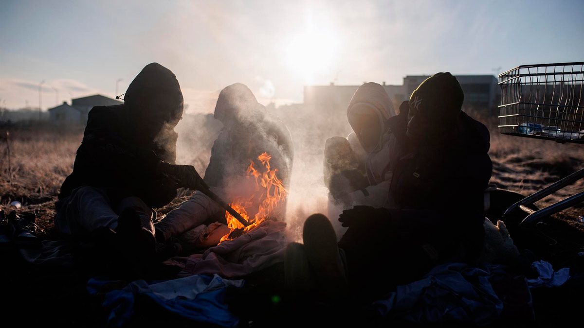 Un grupo de personas ghanesas preparan una hoguera en Medyka, frontera de Polonia con Ucrania. | EP Un grupo de personas ghanesas preparan una hoguera en Medyka, frontera de Polonia con Ucrania. | EP