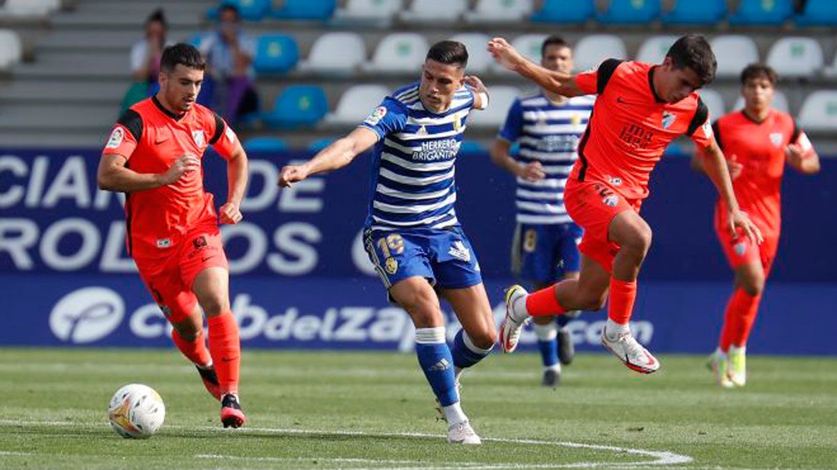 Espiau busca un balón entre dos defensores del Málaga en el choque de la primera vuelta. | LALIGA
