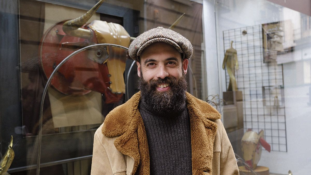 El escultor Juanjo Fernández posa frente al escaparate del arte de la calle Conde Rebolledo. | VICENTE GARCÍA