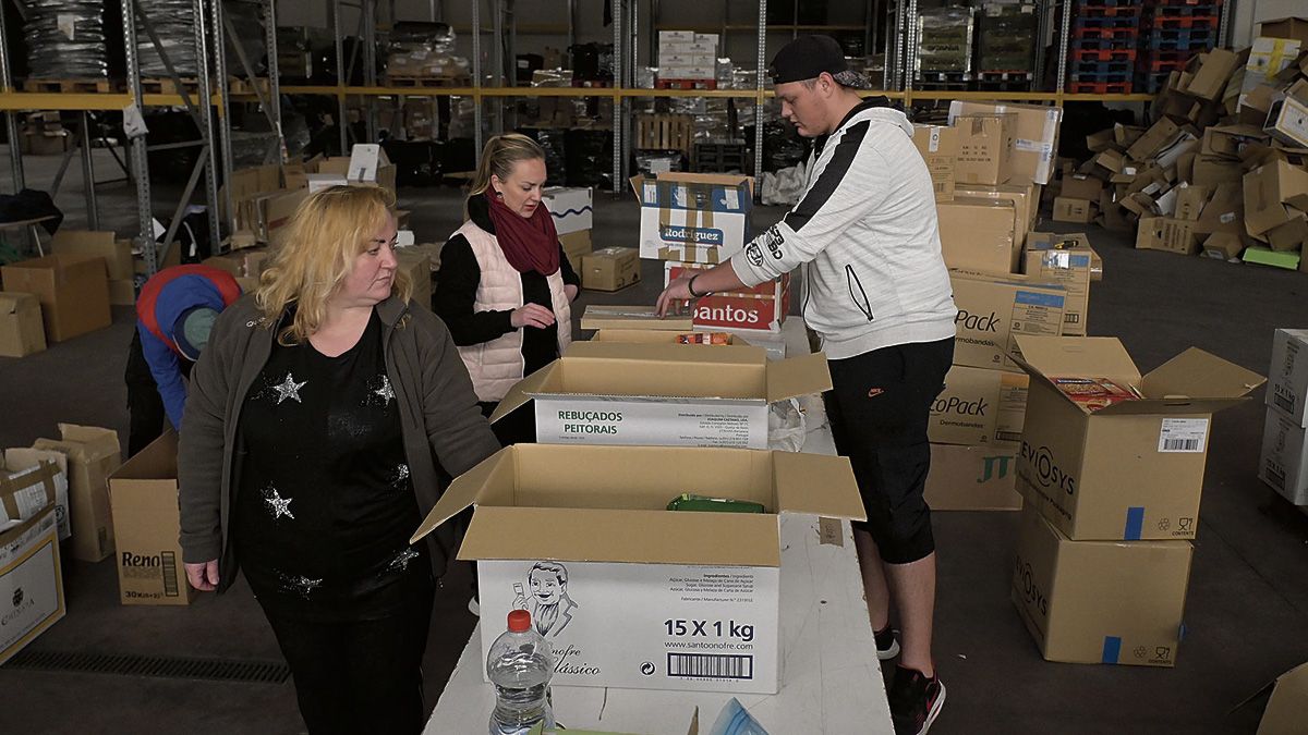 Natalia (primera por la derecha) junto a su hermana Olga y otro de los voluntarios empaquetando ayuda. | MAURICIO PEÑA