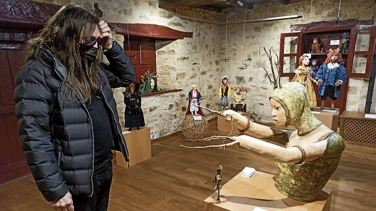 Lolo observando algunas de las obras de la muestra que comparte con creaciones de Etcétera Marionetas de Murias de Rechivaldo. | CM DE SANTA COLOMBA