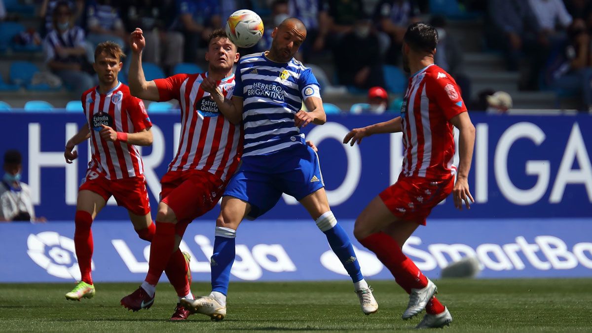 Yuri pelea por un balón dividido con los defensores del Lugo durante el último partido en El Toralín. | SDP