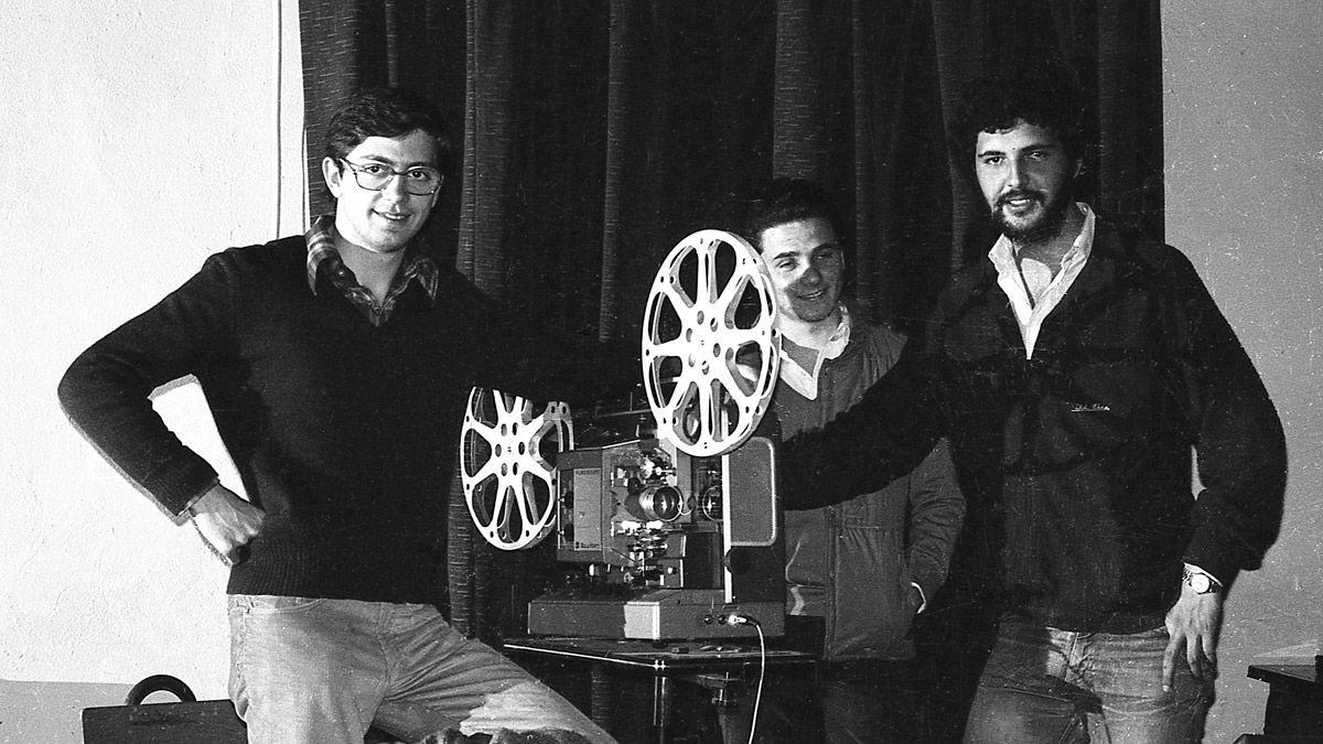 Joaquín Revuelta y José Antonio González Mancebo, miembros de la junta directiva del Cine Club Universitario de León, y el socio Óscar Salazar junto al proyector de 16 mm del IES Juan del Enzina en 1980. | JUAN DÍEZ