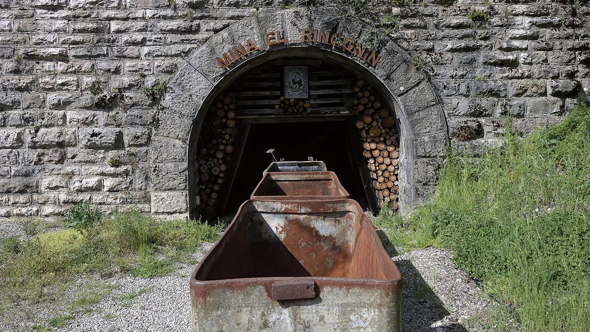 Vagones en la bocamina del simulacro de galería que los exmineros han recreado al lado de las torres y línea de baldes bajadas del monte. | MAURICIO PEÑA