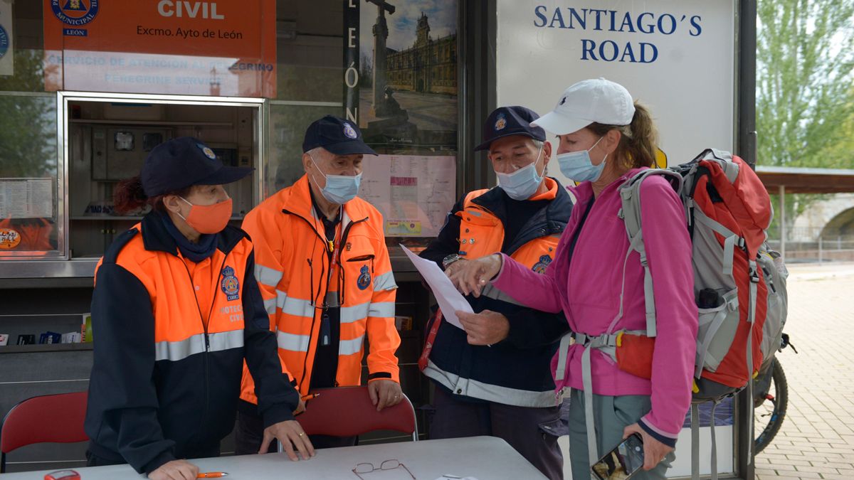 Voluntarios de Protección Civil atendiendo a una peregrina en el punto de Puente Castro. | MAURICIO PEÑA