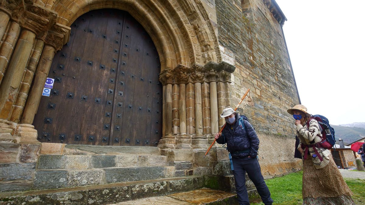 Dos peregrinos en la Puerta del Perdón de la iglesia de Villafranca del Bierzo. | ICAL Dos peregrinos en la Puerta del Perdón de la iglesia de Villafranca del Bierzo. | ICAL