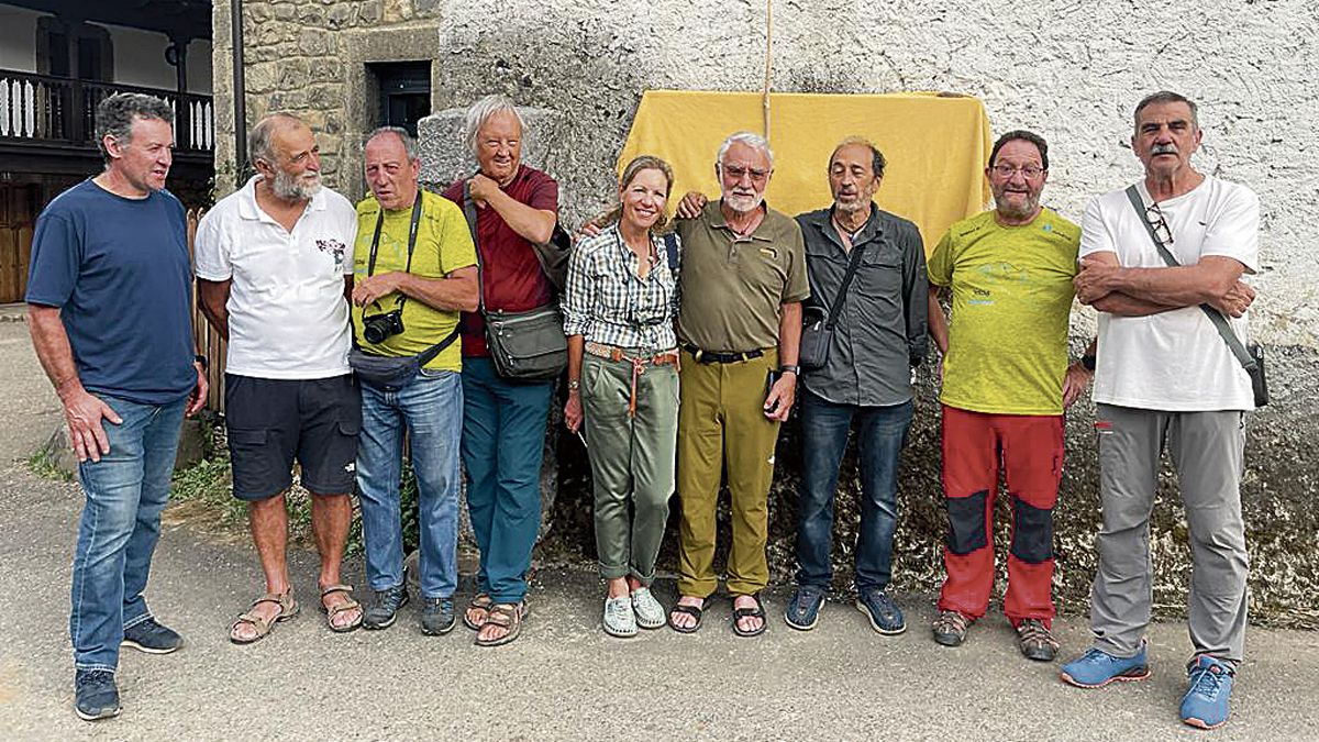 Isidoro Rodríguez Cubillas con un grupo de amigos "de la montaña" bajo la placa de la calle que lleva su nombre en Soto de Valdeón. | ANA ISABEL MARTÍNEZ DE PAZ