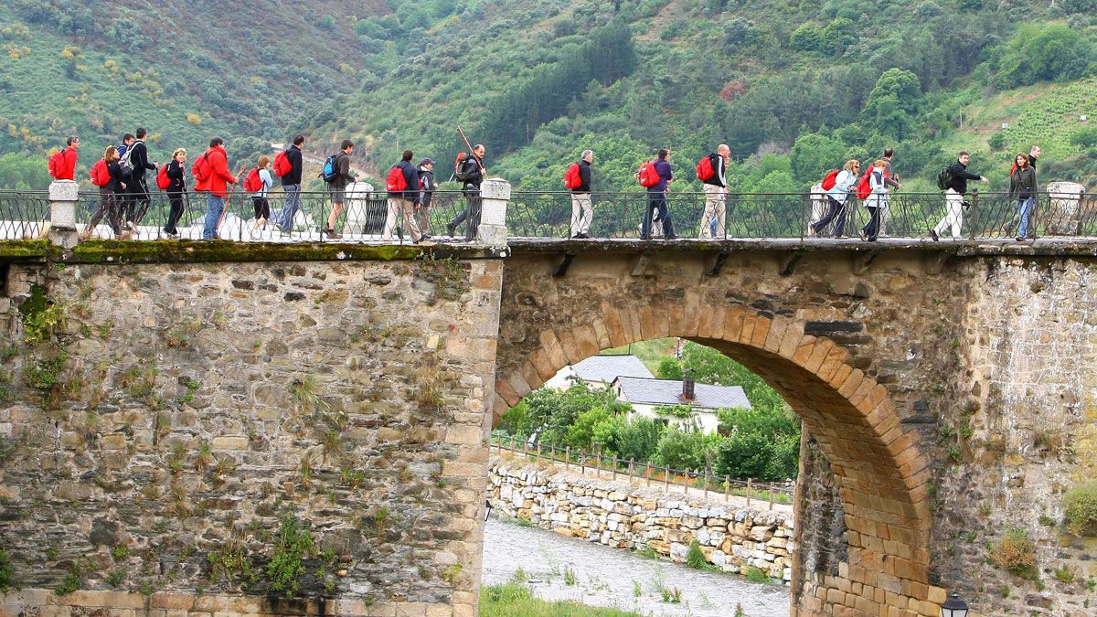 Caminantes sobre el río Burbia, aguas que se pretendían usar para esta central.