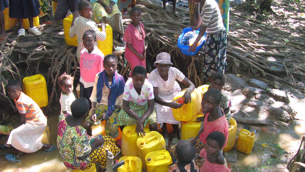 Los niños de Kilela en medio de los bidones con los que cada día cogen agua.