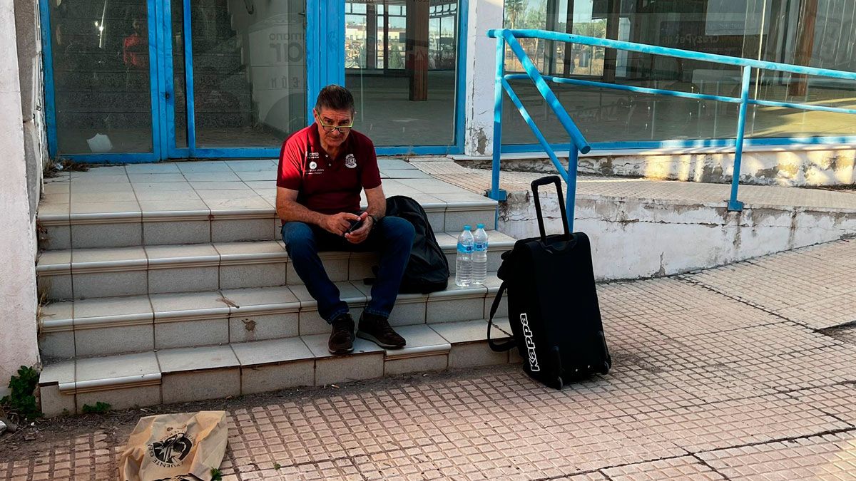Manolo Cadenas espera sentado en una escalera un taxi para poder acudir al pabellón. | CARLOS GARCÍA
