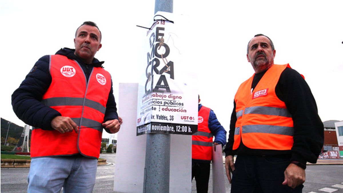 Los secretarios comarcales de UGT y CCOO durante la pega de carteles. | César Sánchez Los secretarios comarcales de UGT y CCOO durante la pega de carteles. | César Sánchez