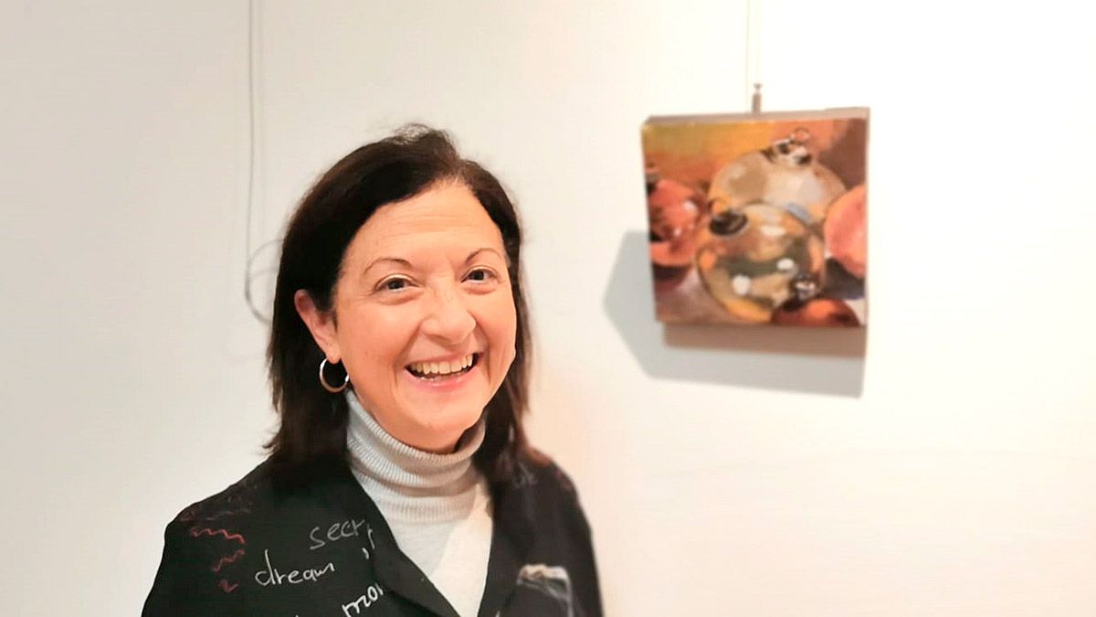 La pintora Pilar L. Duque con su obra en la exposición 'El amigo invisible entre artistas' en galería Cinabrio.