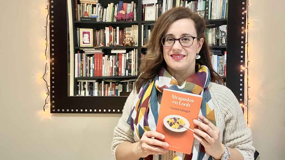 Noemí Sabugal junto a la portada de su libro infantil, ‘Atrapados en Looh’. | PABLO J. CASAL