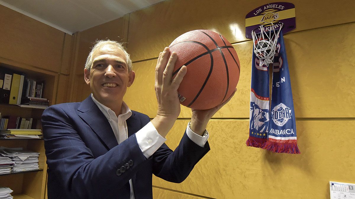 Vicente Canuria, con un balón de baloncesto y la canasta que tiene en su despacho. | SAÚL ARÉN