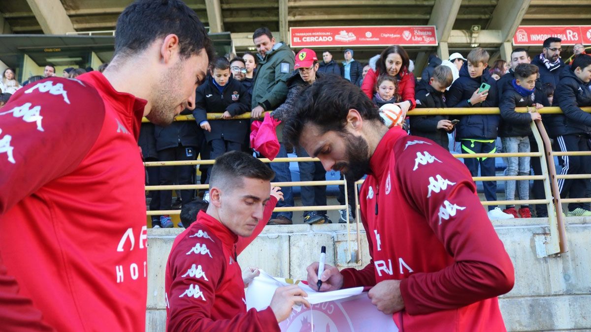 Claudio, Íñigo y Fran Cruz firman una bandera en el entreno de este jueves. | CYD