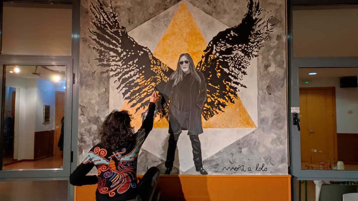 Moñi, de espaldas, dando las últimas pinceladas al mural que en memoria de Lolo quedará para siempre en la Casa de Cultura de Armunia.