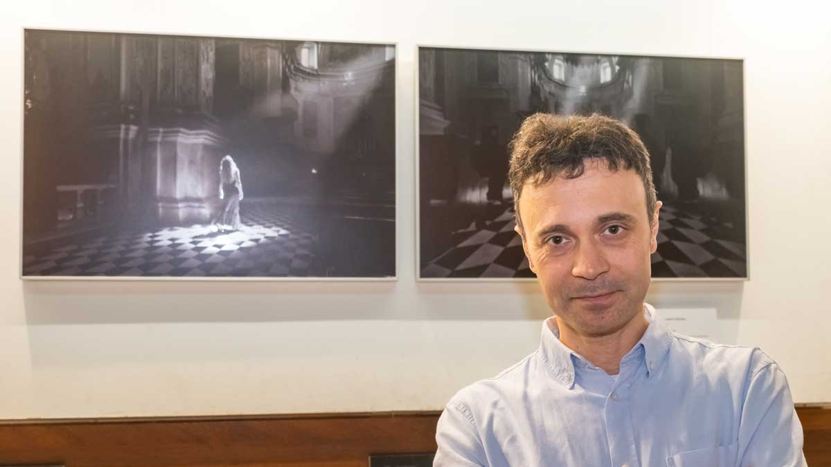 El artista Óscar R. Lobato junto a sus dos fotografías expuestas en el Camarote . | Vicente García