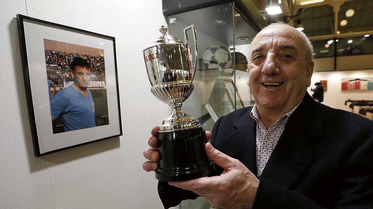 Marianín, con el trofeo Pichichi, al lado de una foto suya en el Real Oviedo | F.REAL OVIEDO