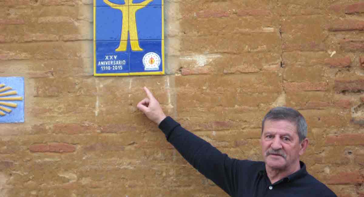 Luis Gutiérrez Perrino señala el emblema de hospilateros voluntarios que este año cumple 25 años de su constitución.