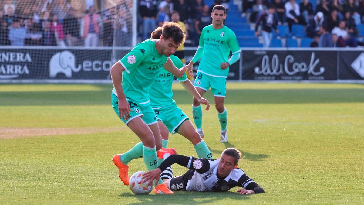 Percan intenta llevarse un balón que el defensor corta con la mano desde el suelo. :: reportaje gráfico: irene rc