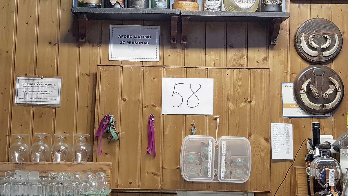 En la estantería, rodeado de botellas o moscas de pesca, aparece el cartel del 58.