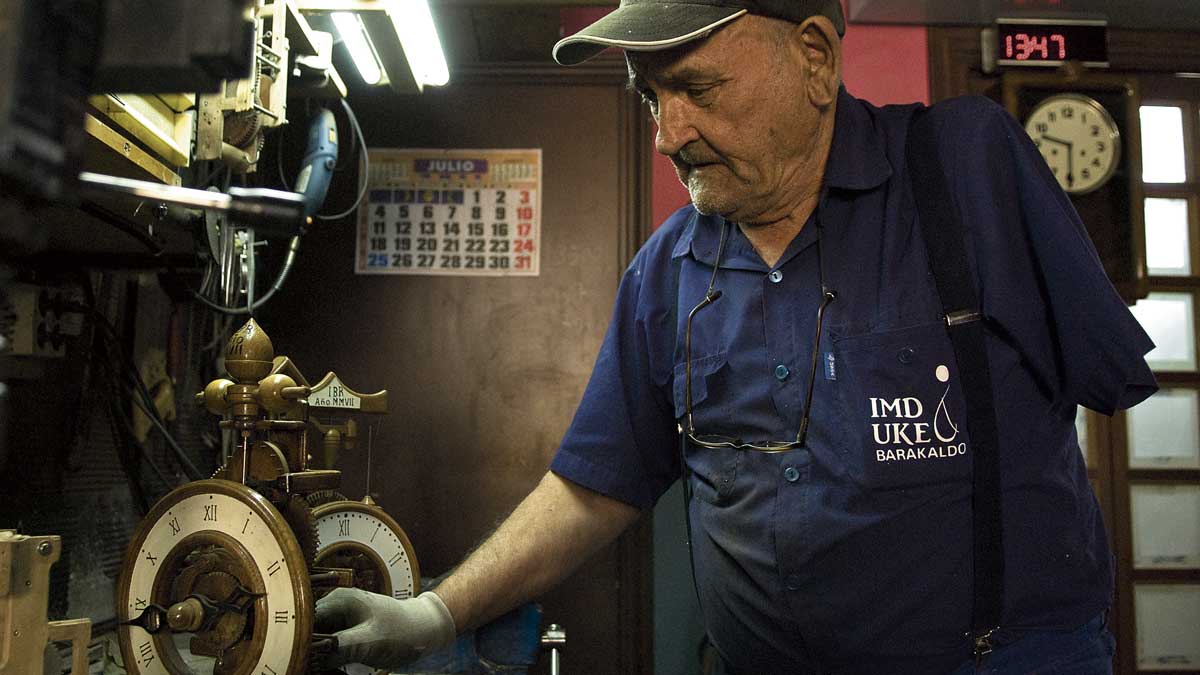 Sasi ‘el manco’ de Mondreganes comprobando la maquinaria de uno de los numerosos relojes que construyó en el taller de su casa. | MAURICIO PEÑA