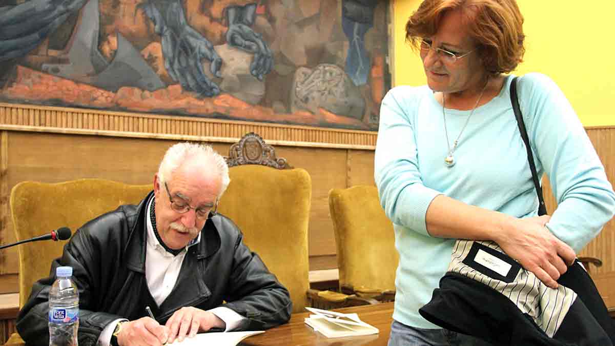 Juan García Campal firma ejemplares de uno de sus libros en presencia de la escultora Charo Acera, presentes ambos en el encierro. | JUAN LUIS GARCÍA