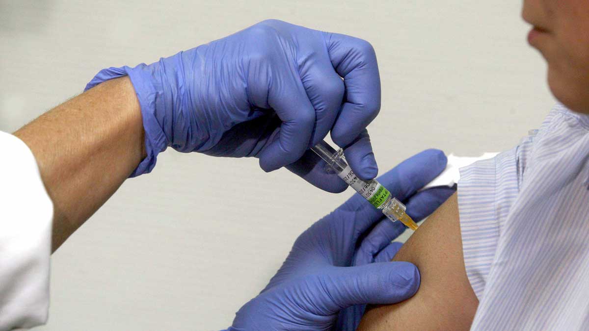 Un sanitario aplica una vacuna a un paciente en una foto de archivo. | ICAL