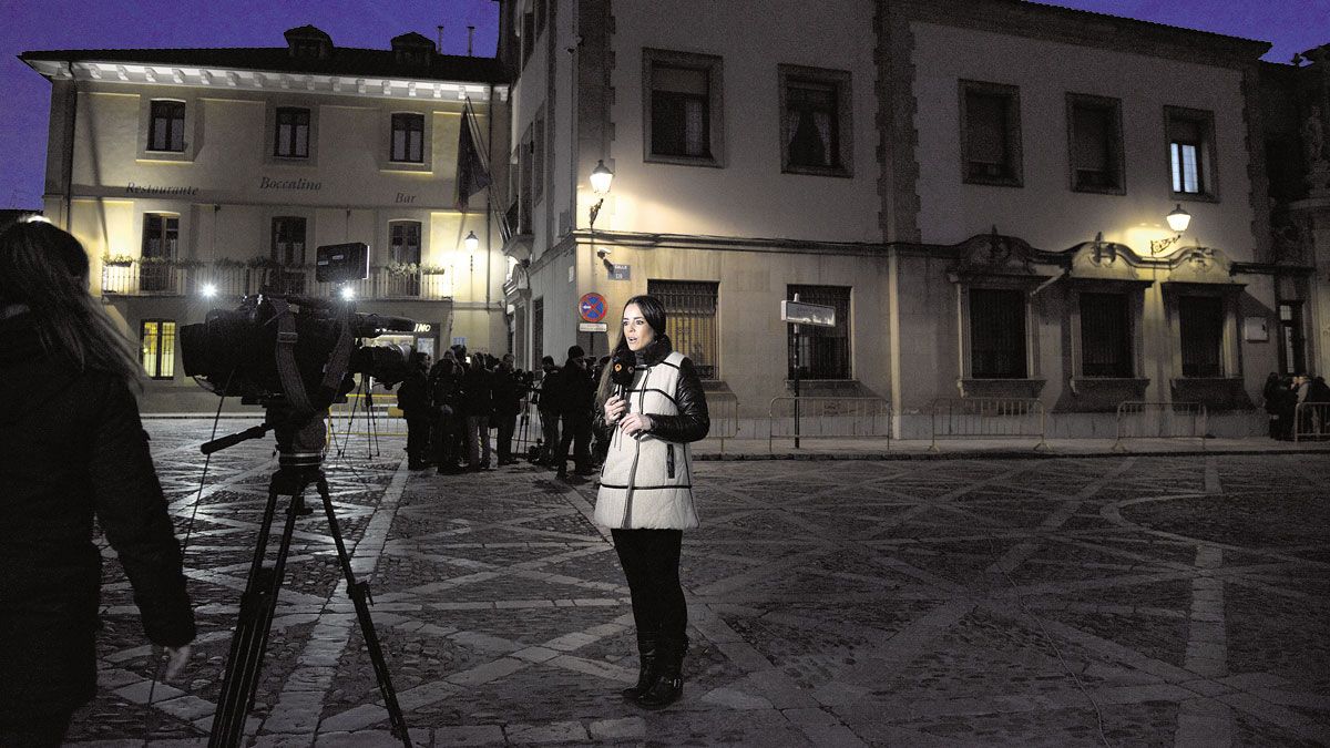 Una periodista entra en directo para una televisión cuando aún no ha amanecido del todo en León. | MAURICIO PEÑA / DANIEL MARTÍN