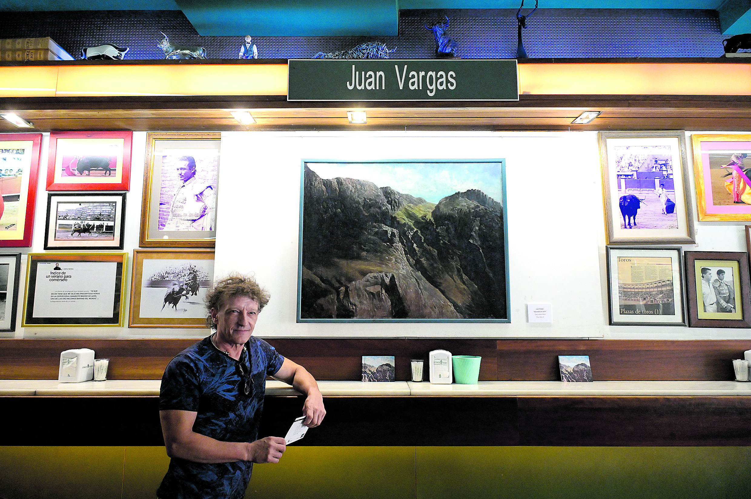Juan Vargas, hijo del pintor Alejandro Vargas, posa junto a ‘La montaña de León’, un óleo sobre tabla que cuelga en la pared del Camarote. | MAURICIO PEÑA