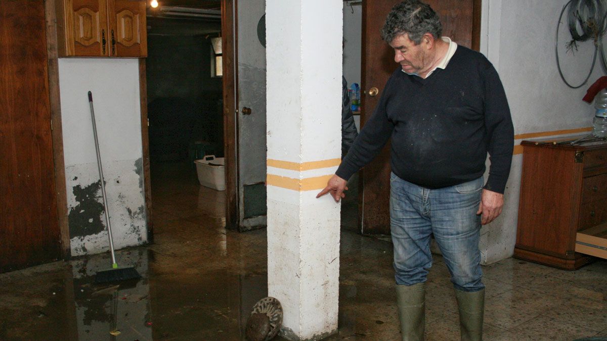 José Rodríguez, vecino de Villaverde de los Cestos, indica el nivel del agua acumulada en el bajo de su casa. | CÉSAR SÁNCHEZ (ICAL)