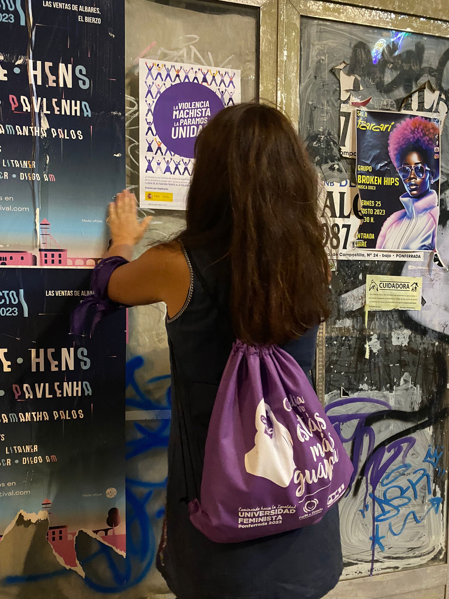 Una de las voluntarias colocando un cartel sobre los Puntos Violeta. 