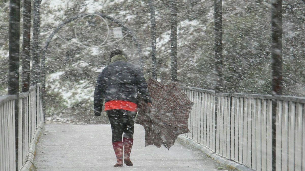 Una mujer camina bajo la intensa nieve en el municipio de Matarrosa del Sil. | CÉSAR SÁNCHEZ (ICAL)