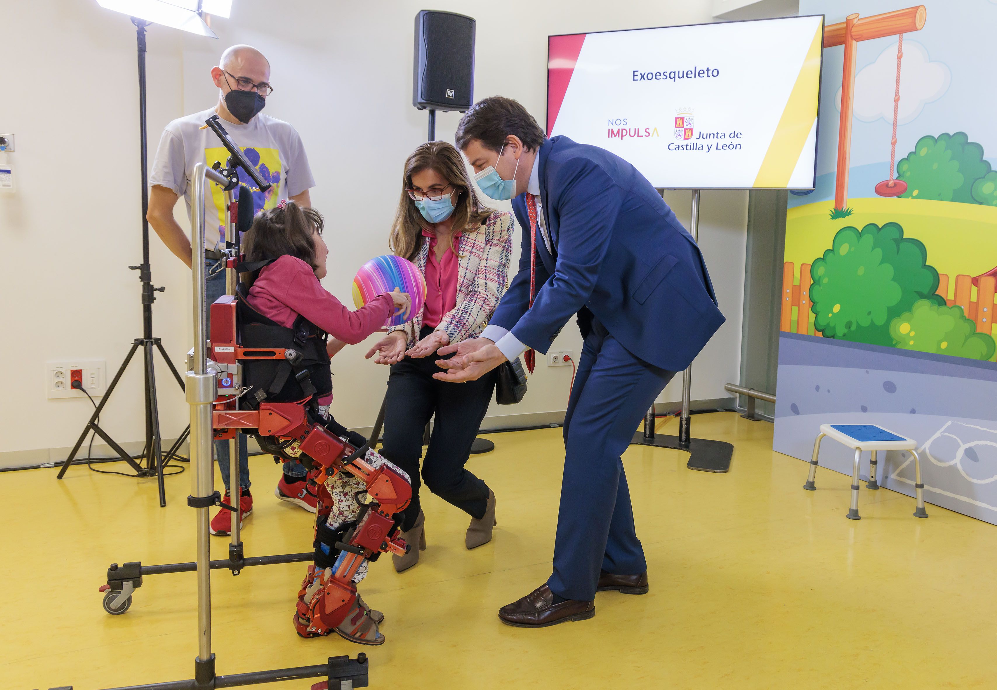 El presidente de la Junta, Alfonso Fernández Mañueco, junto a Lola, la niña que ha probado el exoesqueleto. | JCYL