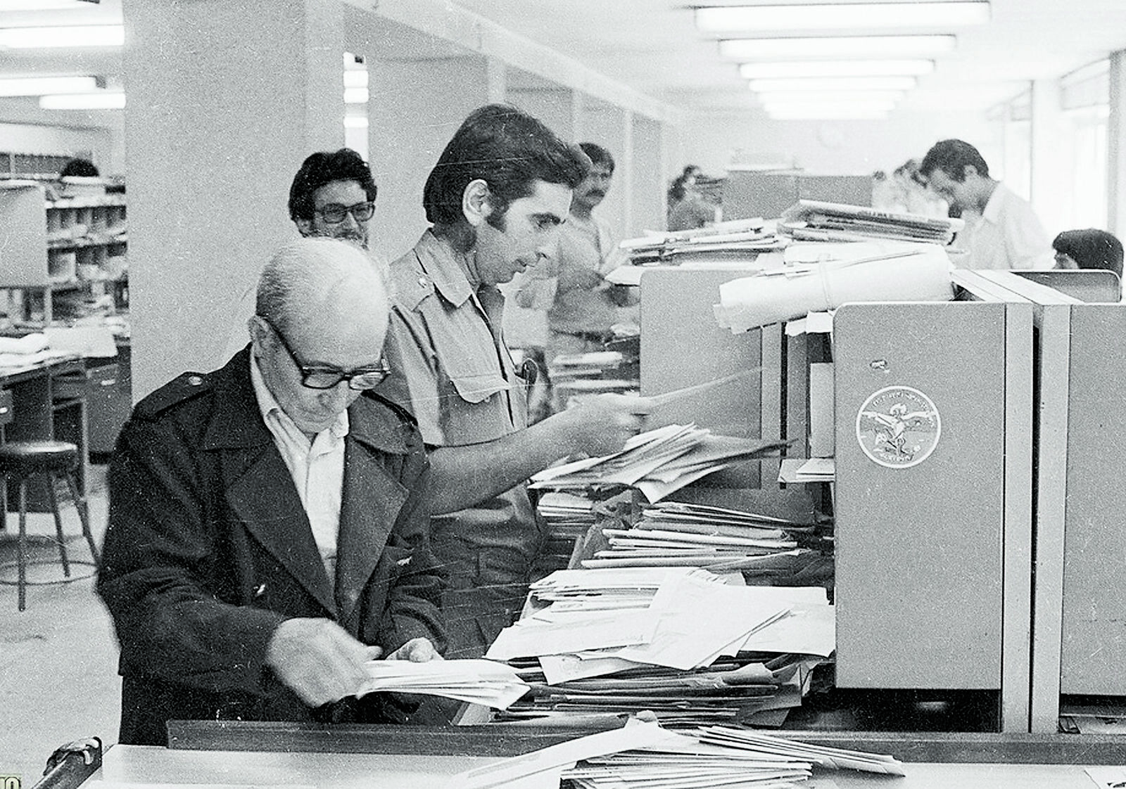 Varios trabajadores de la oficina preparando el reparto para sus destinos. |FERNANDO RUBIO