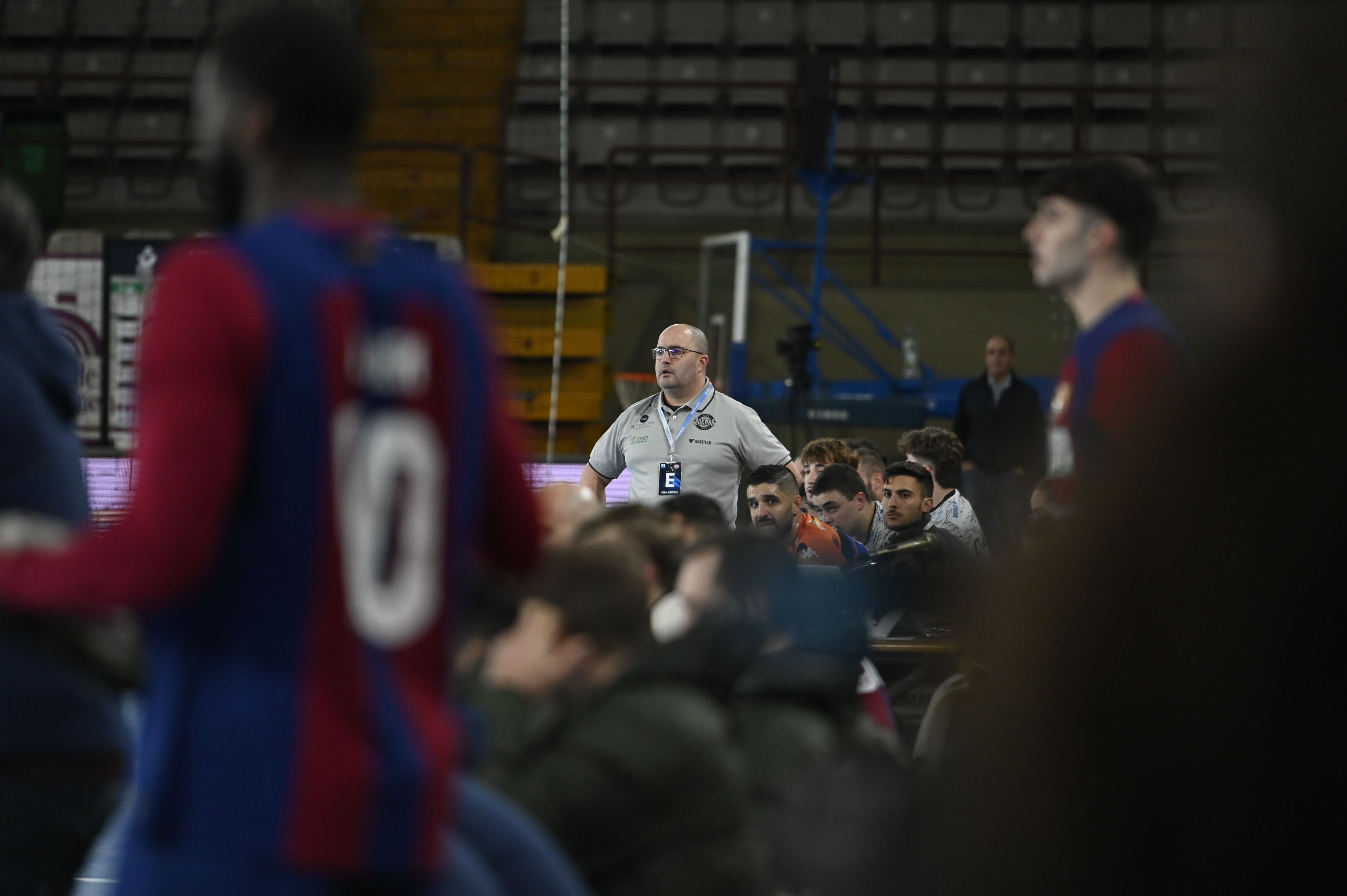 Dani Gordo, en manga corta como sus jugadores de banquillo, mientras los del Barcelona están con el anorak puesto. | SAÚL ARÉN