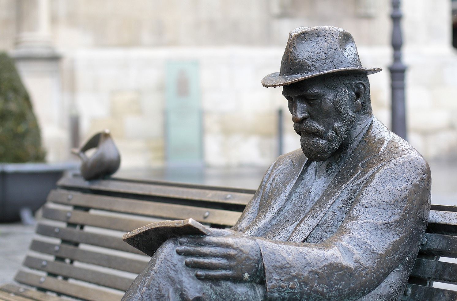 Antonio Gaudí, sentado en un banco frente al palacio, obra en bronce del escultor asturiano José Luis Fernández. | MUSEO CASA BOTINES GAUDÍ