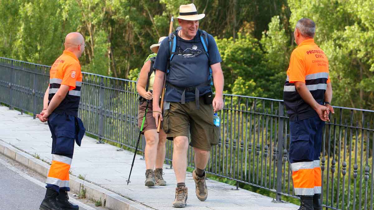 Miembros de la Agrupación de Protección Civil del Consejo Comarcal del Bierzo  atienden a peregrinos a su llegada a Molinaseca. | ICAL