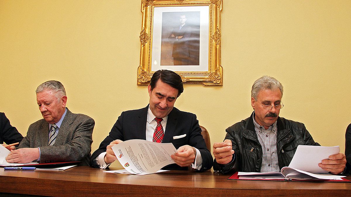 El consejero de Fomento y Medio Ambiente, Juan Carlos Suárez-Quiñones (C), firma un convenio con el alcalde de de Laguna de Negrillos, Ángel Valencia (I) y el de Villamañán, Higinio García (D). | ICAL