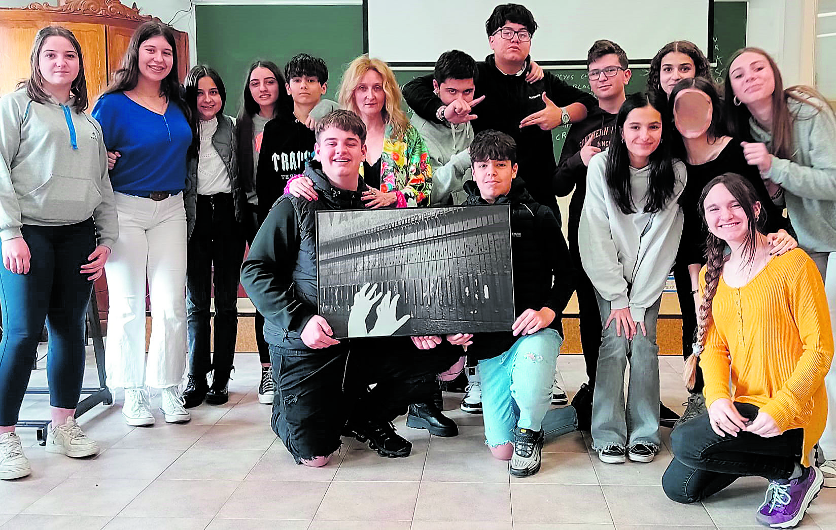 Carmen Coque posa con alumnos de la ESO del Colegio Maristas San José que sostienen la fotografía. | L.N.C.