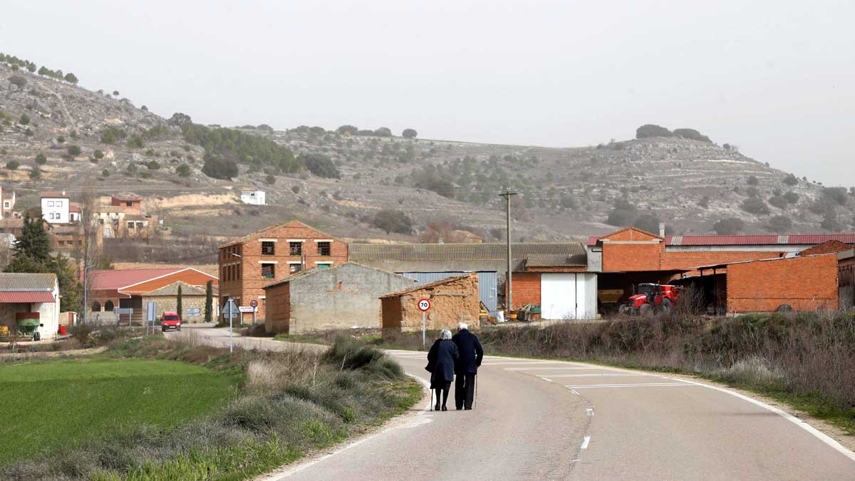 Pareja de personas mayores paseando por la carretera de Valdearcos de la Vega (Valladolid) | ICAL
