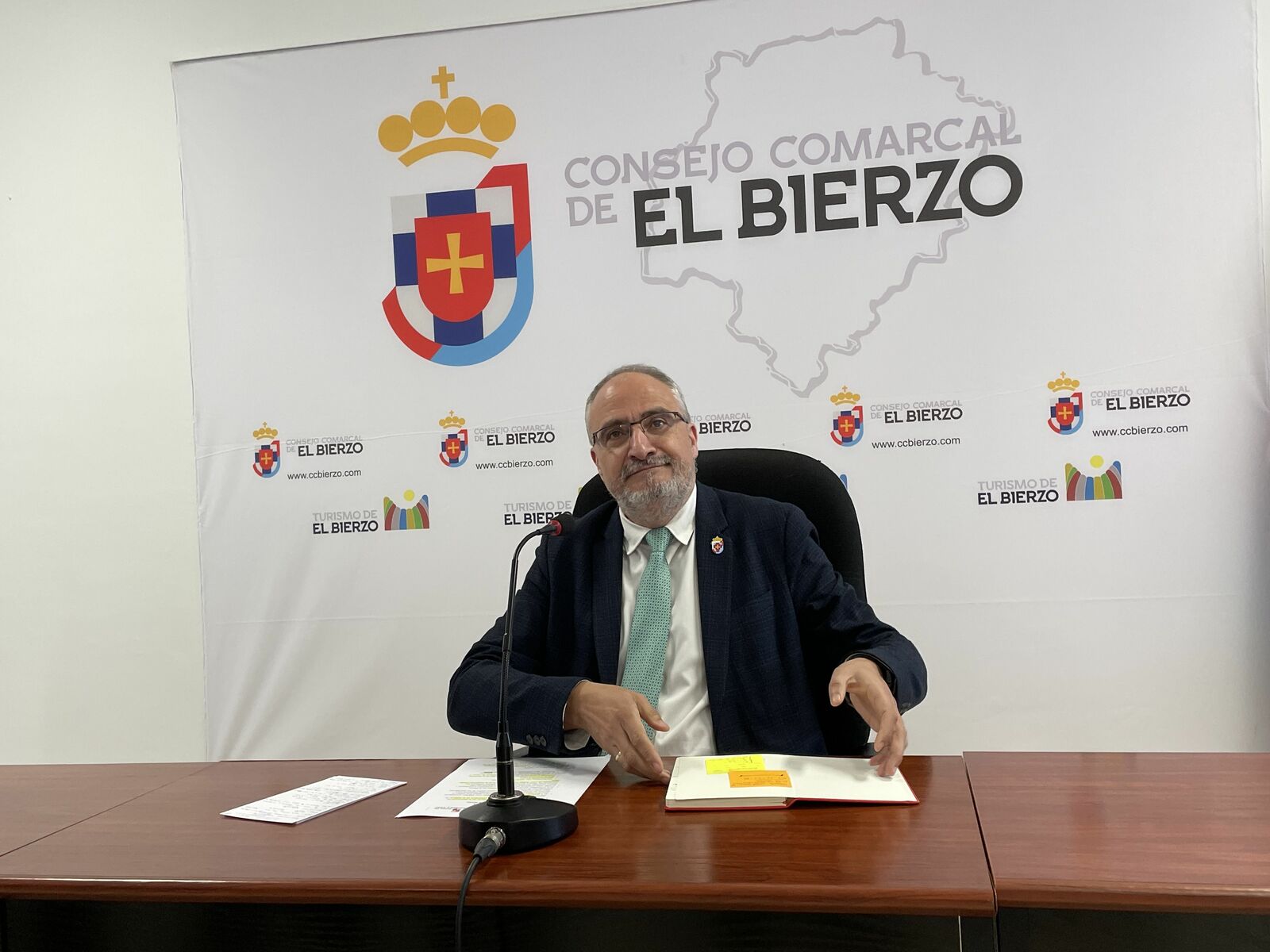 Olegario Ramón en la sede del Consejo Comarcal, con el rótulo con la fórmula incorrecta a sus espaldas. | Javier Fernández