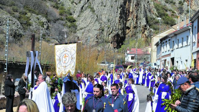 La procesión de los Ramos volvió a recorrer la calle que camina al lado del Bernesga para cruzar el puente y ‘desembocar’ en la iglesia. | F. FERNÁNDEZ