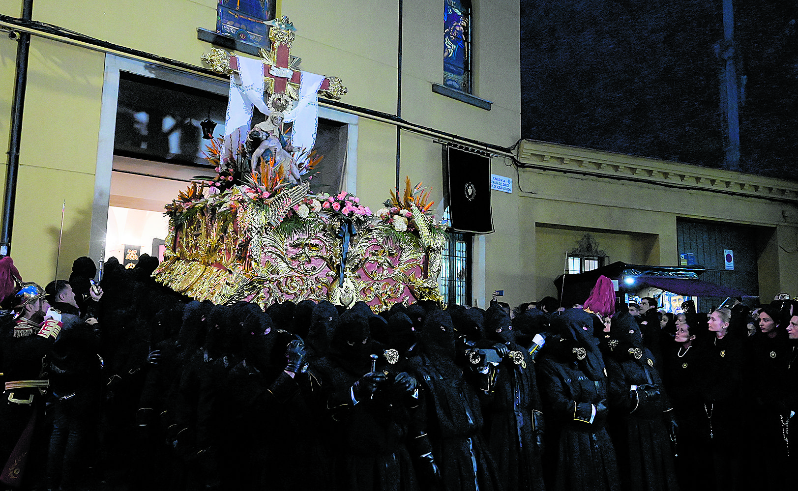 La Virgen de las Angustias sale de la capilla de Santa Nonia ante la atenta mirada de las manolas. | MAURICIO PEÑA