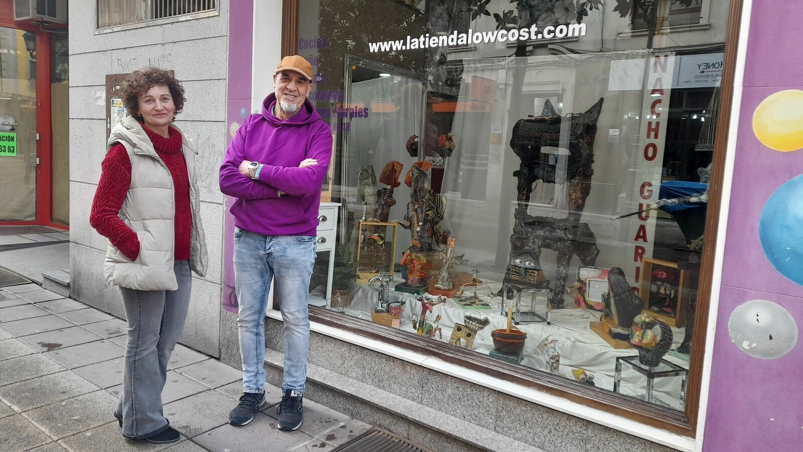 Marga y Nacho al lado del escaparate reconvertido en una pequeña galería de arte a los ojos de la calle. | MAR IGLESIAS