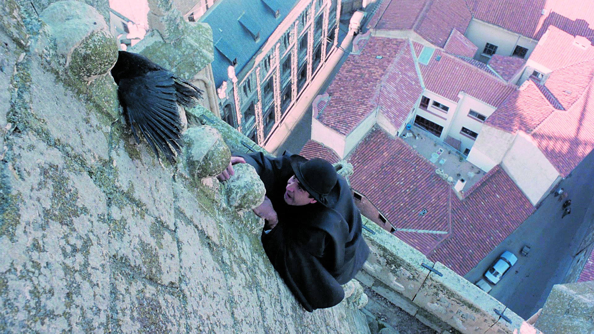 El actor Félix Cañal, en el papel de don Santos, escala por la Catedral de León en el relato ‘Los grajos del sochantre’ de ‘El filandón’. | FILMIN