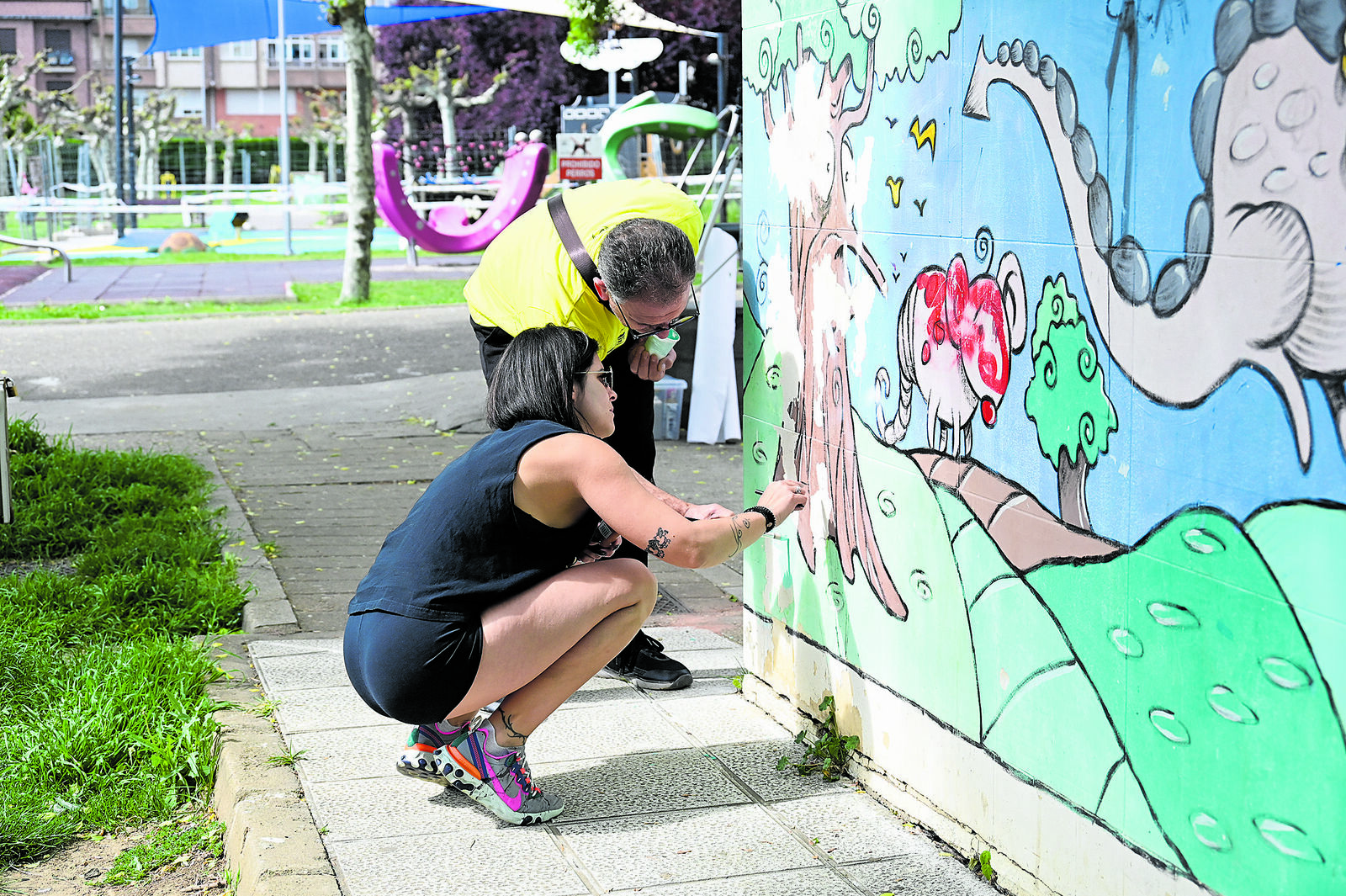 Laia trabajando en la restauración del mural que había realizado su padre en Villaquilambre. | SAÚL ARÉN