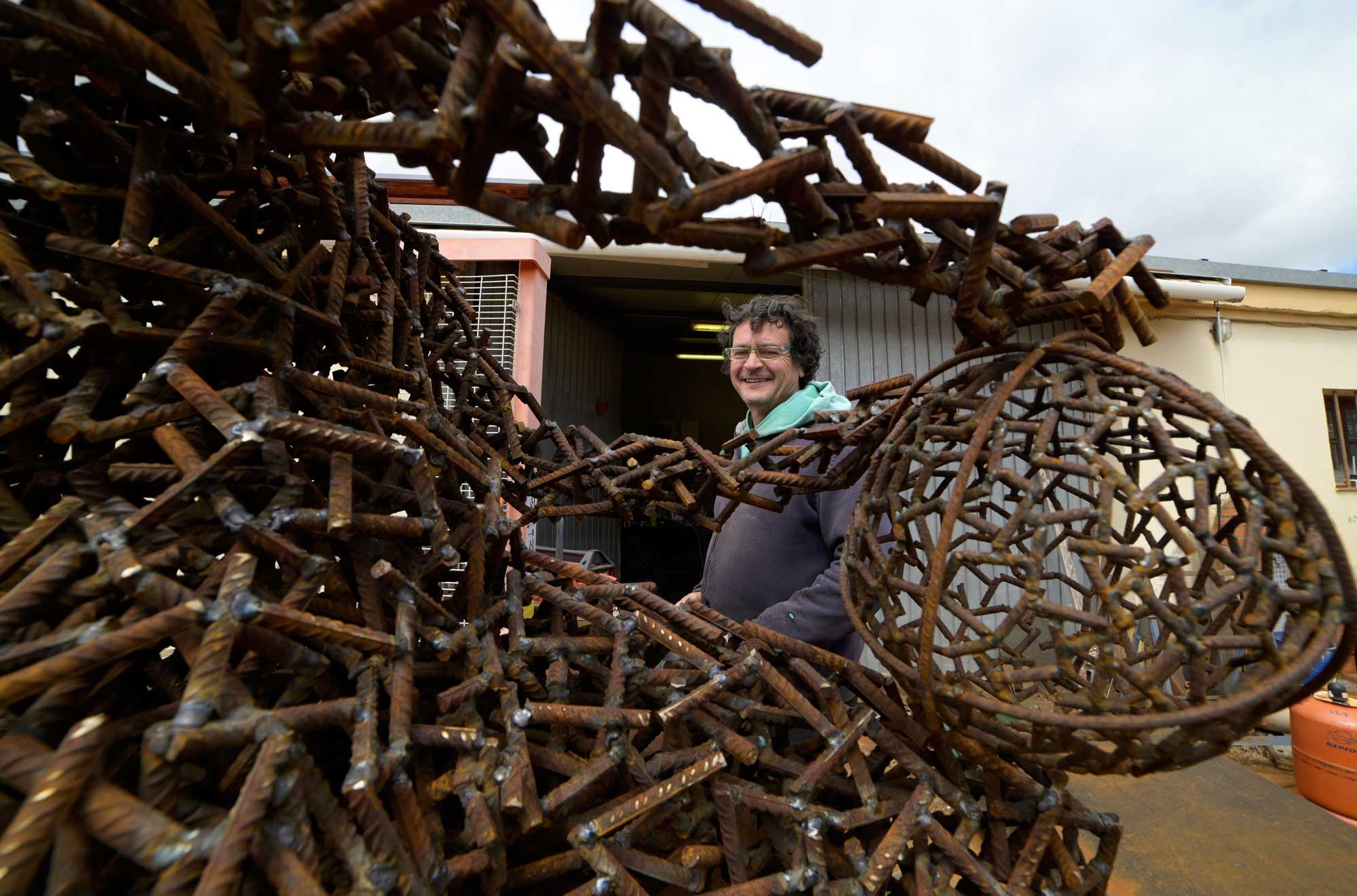 Amancio se asoma a una de las esculturas en las que está trabajando en su taller. | MAURICIO PEÑA