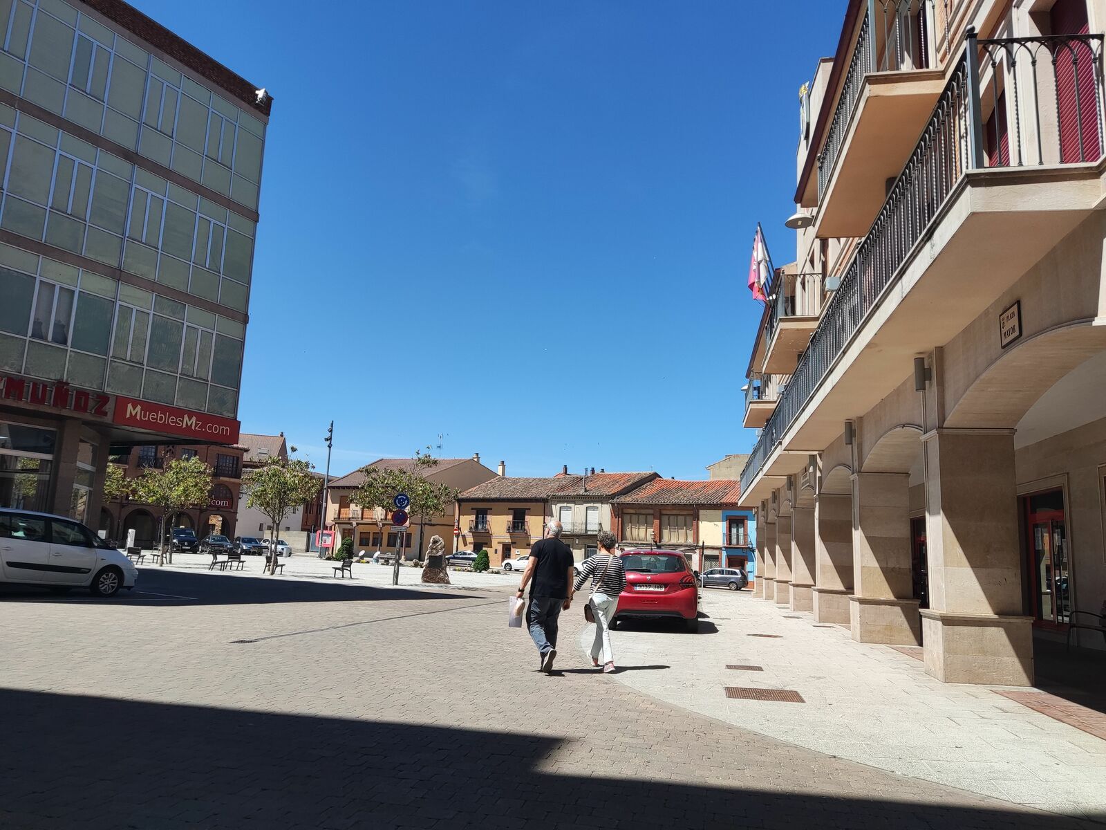 Una pareja caminando este miércoles por la plaza Mayor de Valencia de Don Juan. | A.R.