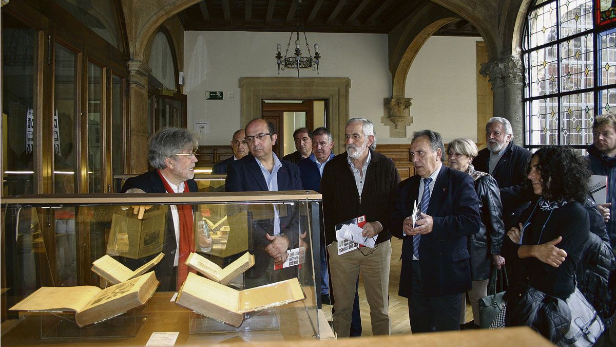 Luis Carnicero muestra a miembros de la corporación provincial algunas de las ediciones del Quijote.